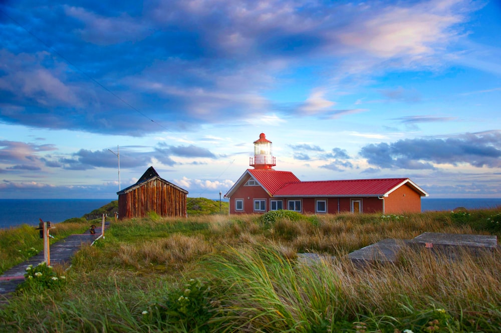 brown wooden house on green grass field under blue sky during daytime