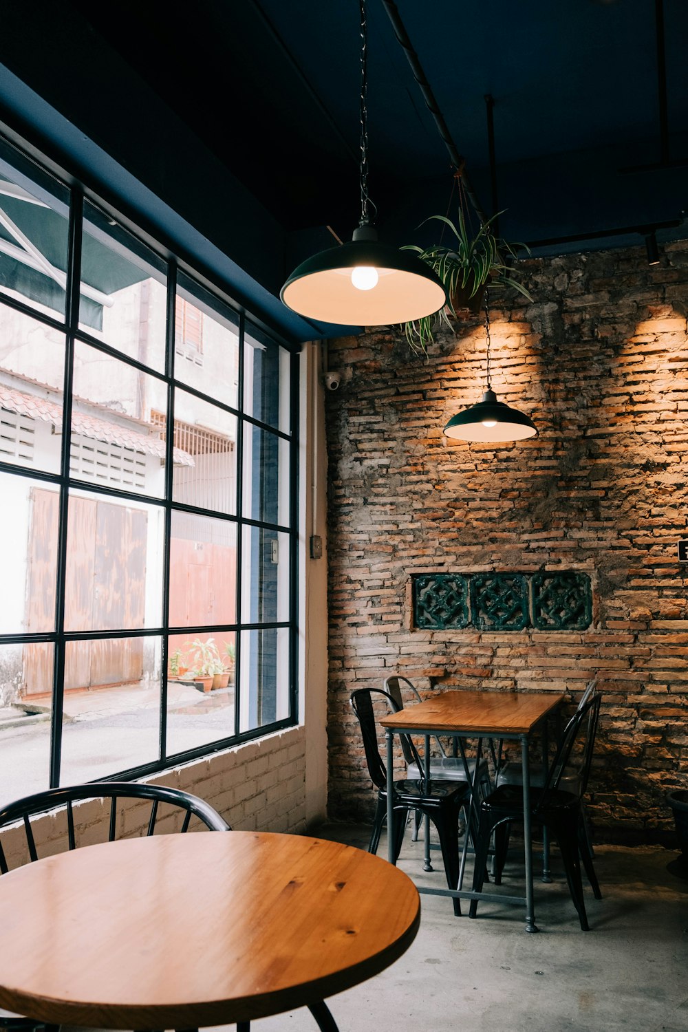 black pendant lamp turned on near glass window