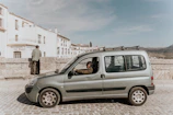 Close-up of a professional driver opening a van door in a city setting.