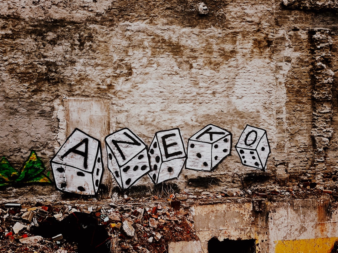 white and black graffiti on brown concrete wall