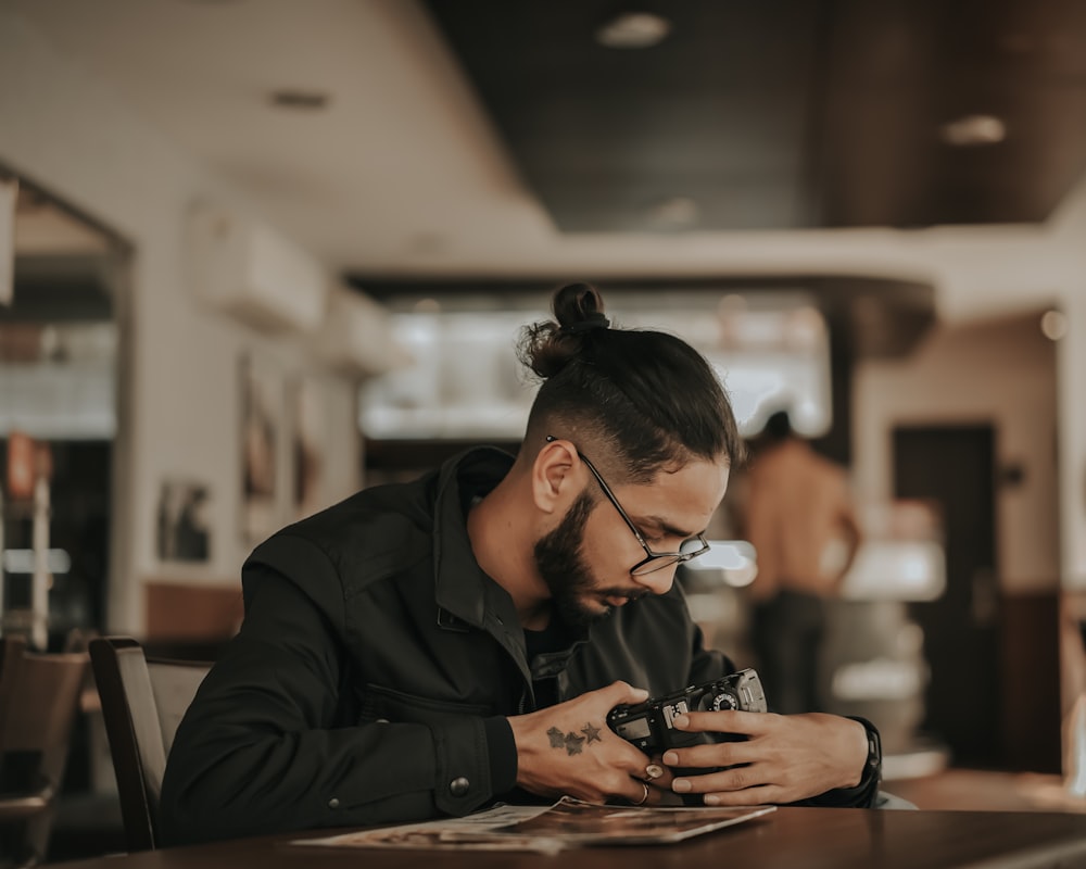 man in black coat using smartphone