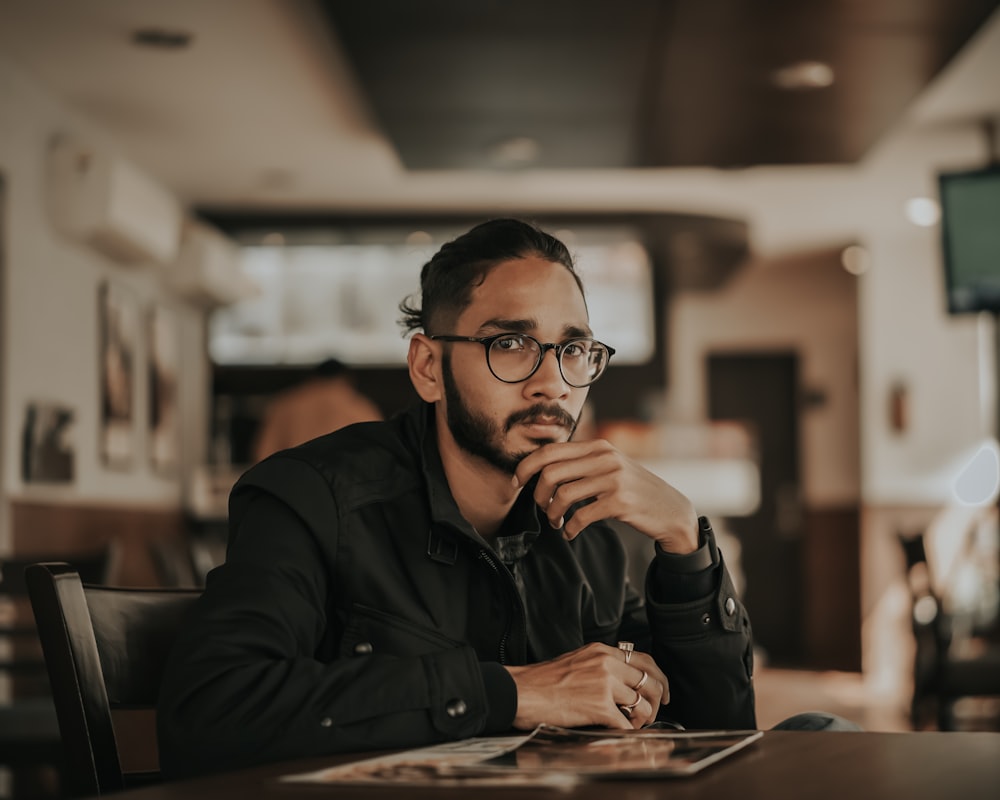 man in black jacket wearing eyeglasses