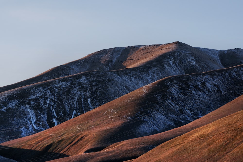 brown and black mountain under gray sky