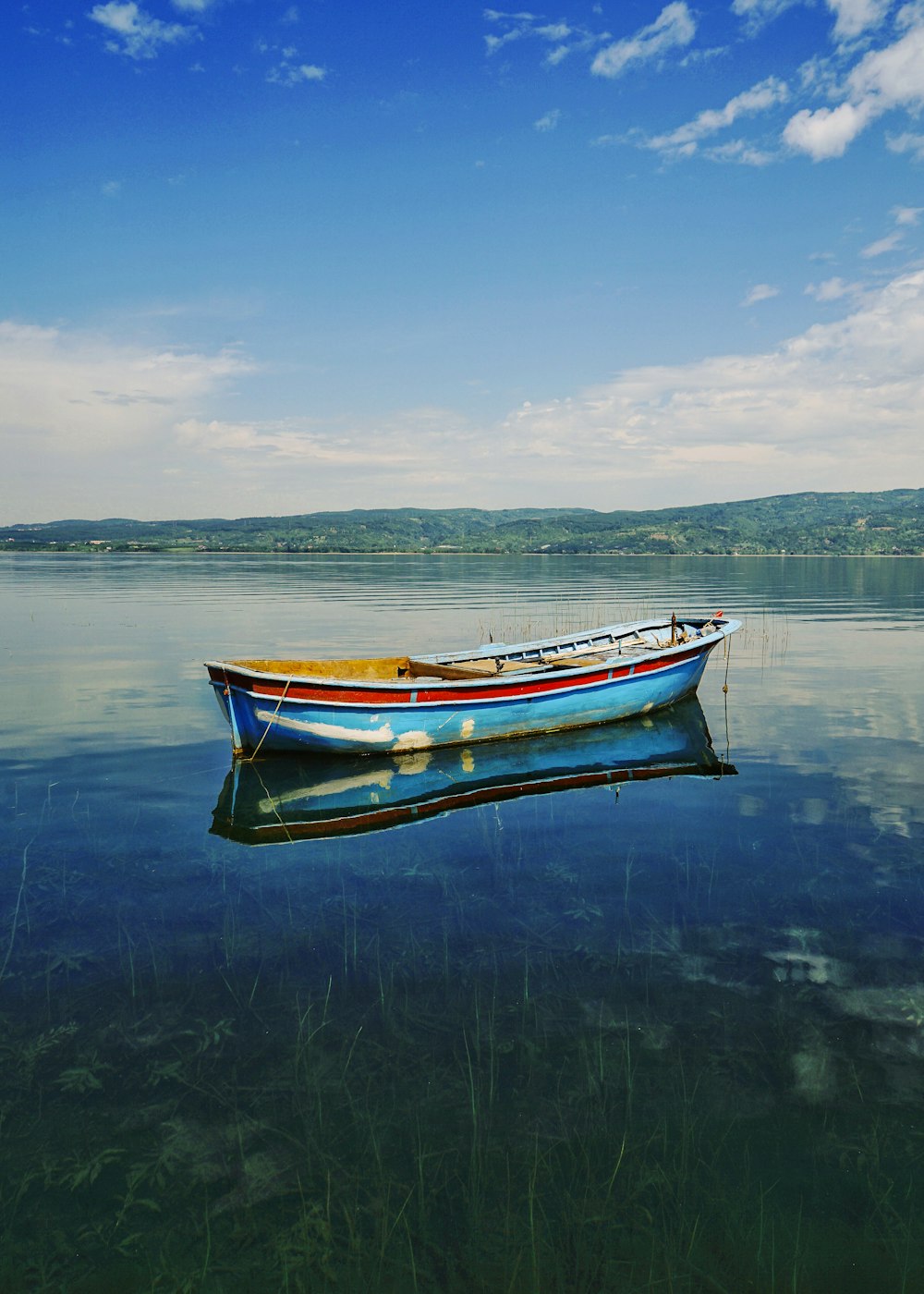 white and blue boat on water under blue sky during daytime