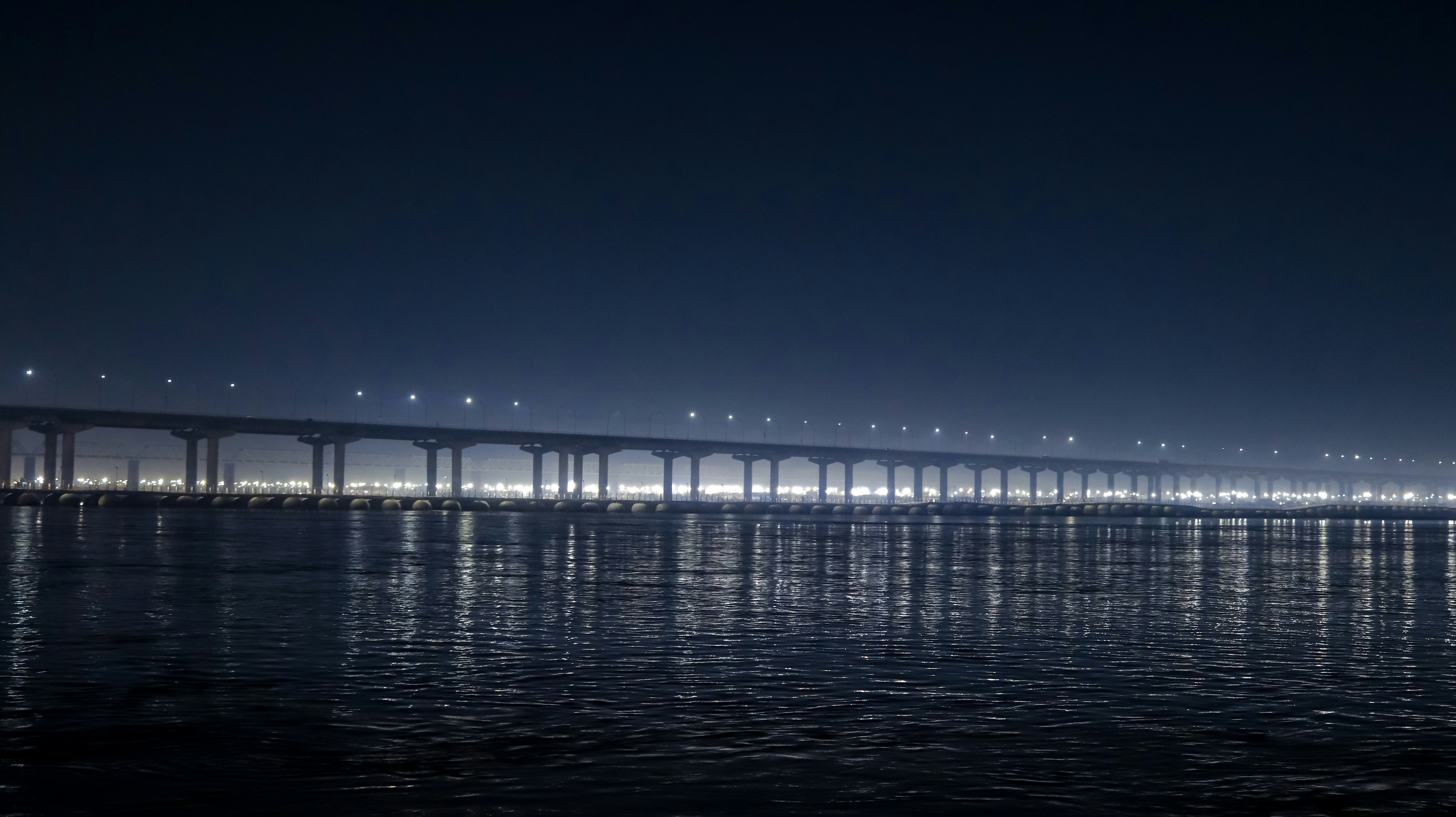 white bridge on body of water during night time