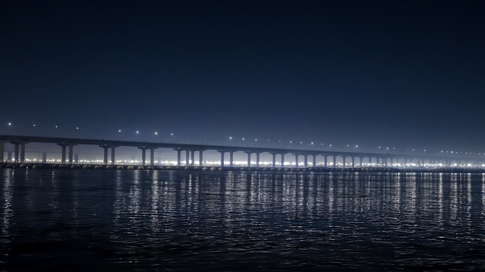 white bridge on body of water during night time