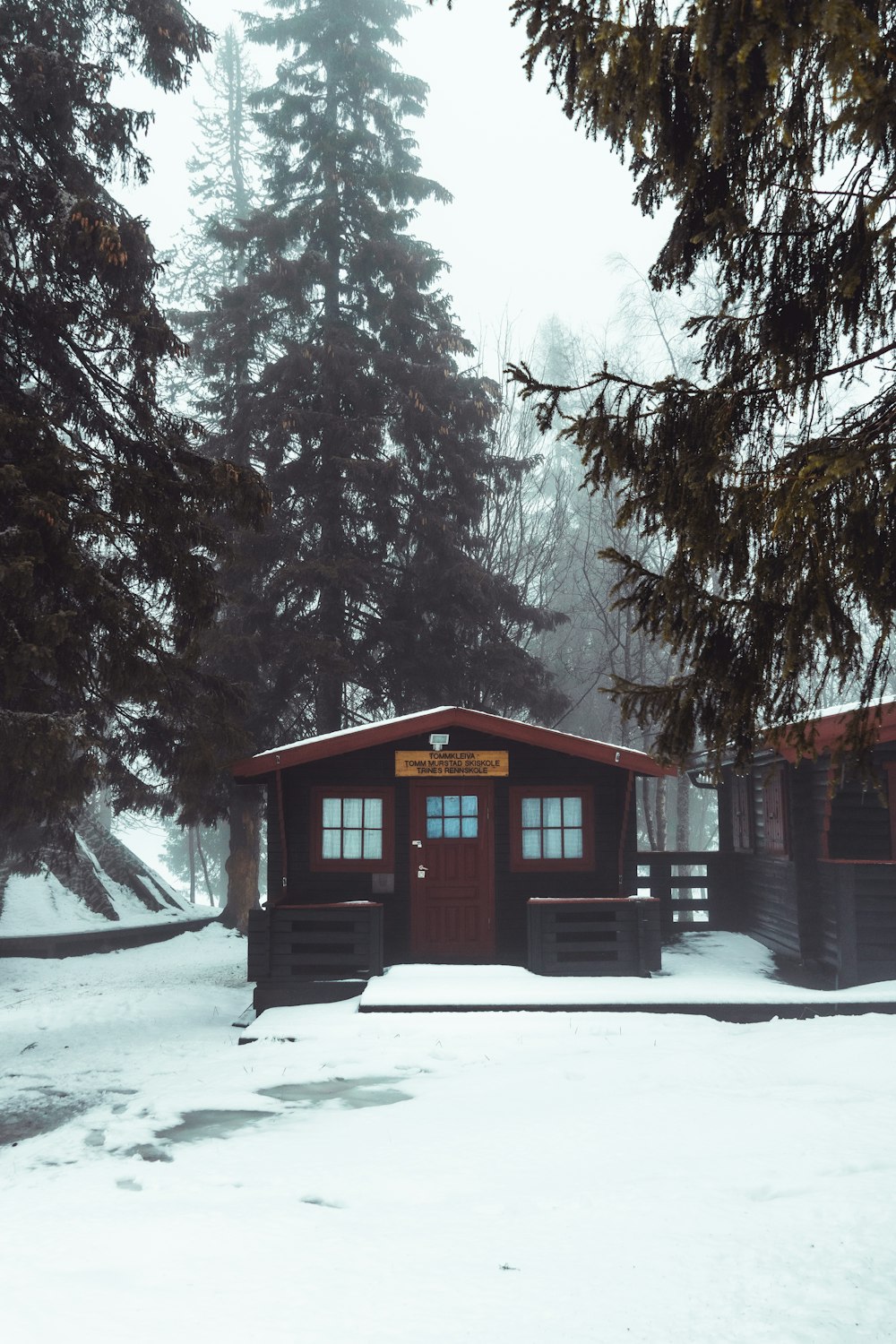 brown wooden house on snow covered ground