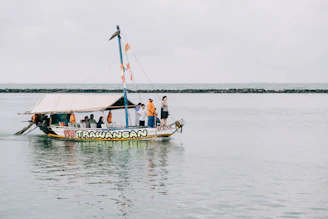 Tourists enjoying a boat trip around Gili Trawangan island under clear blue skies.