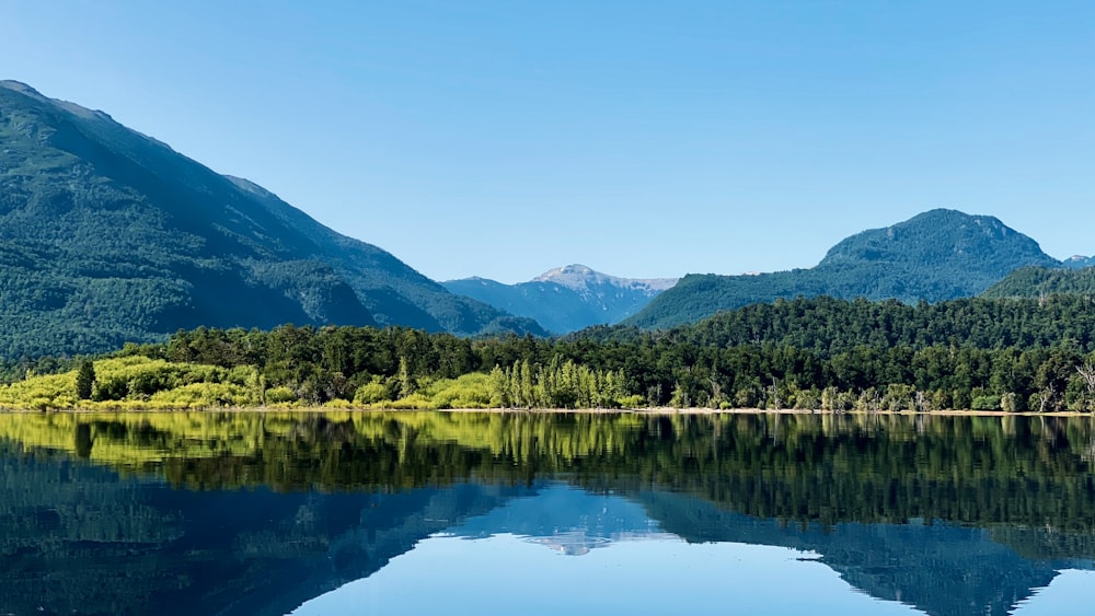 green mountains near body of water during daytime