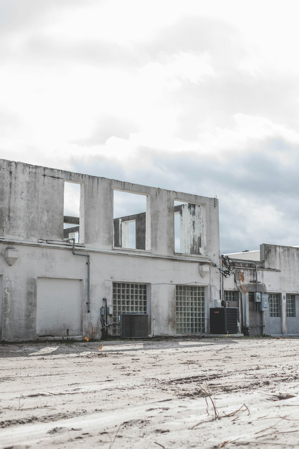 edifício de concreto branco sob nuvens brancas durante o dia