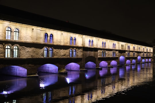 brown concrete bridge over river during night time in Barrage Vauban France