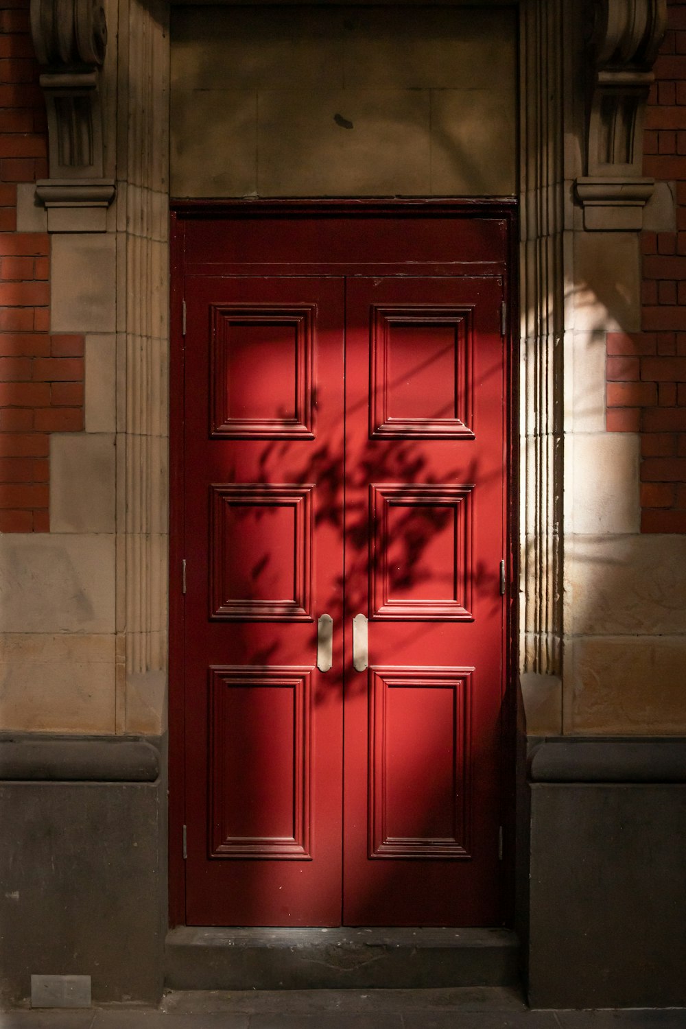 red wooden door on gray concrete wall