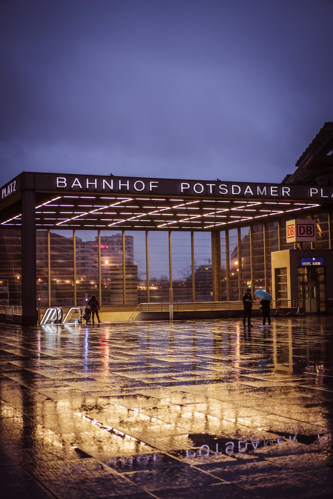 people walking on sidewalk near building during night time