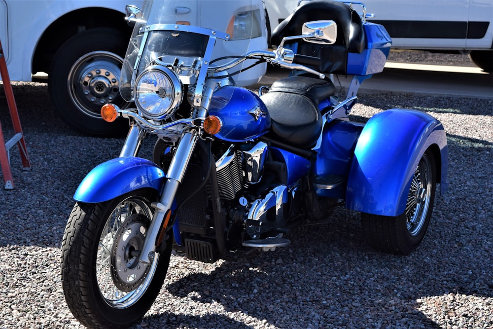 motocicleta azul e preta na estrada de asfalto cinza durante o dia