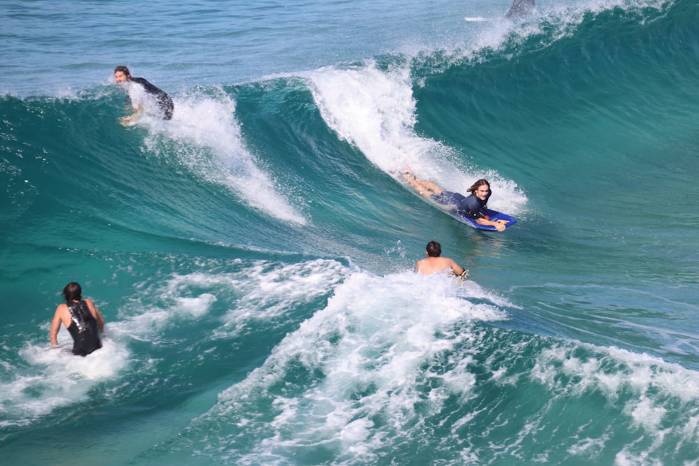 2 people surfing on sea during daytime