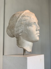 A hand-drawn classical bust on vellum, edges softly curling under ambient light.