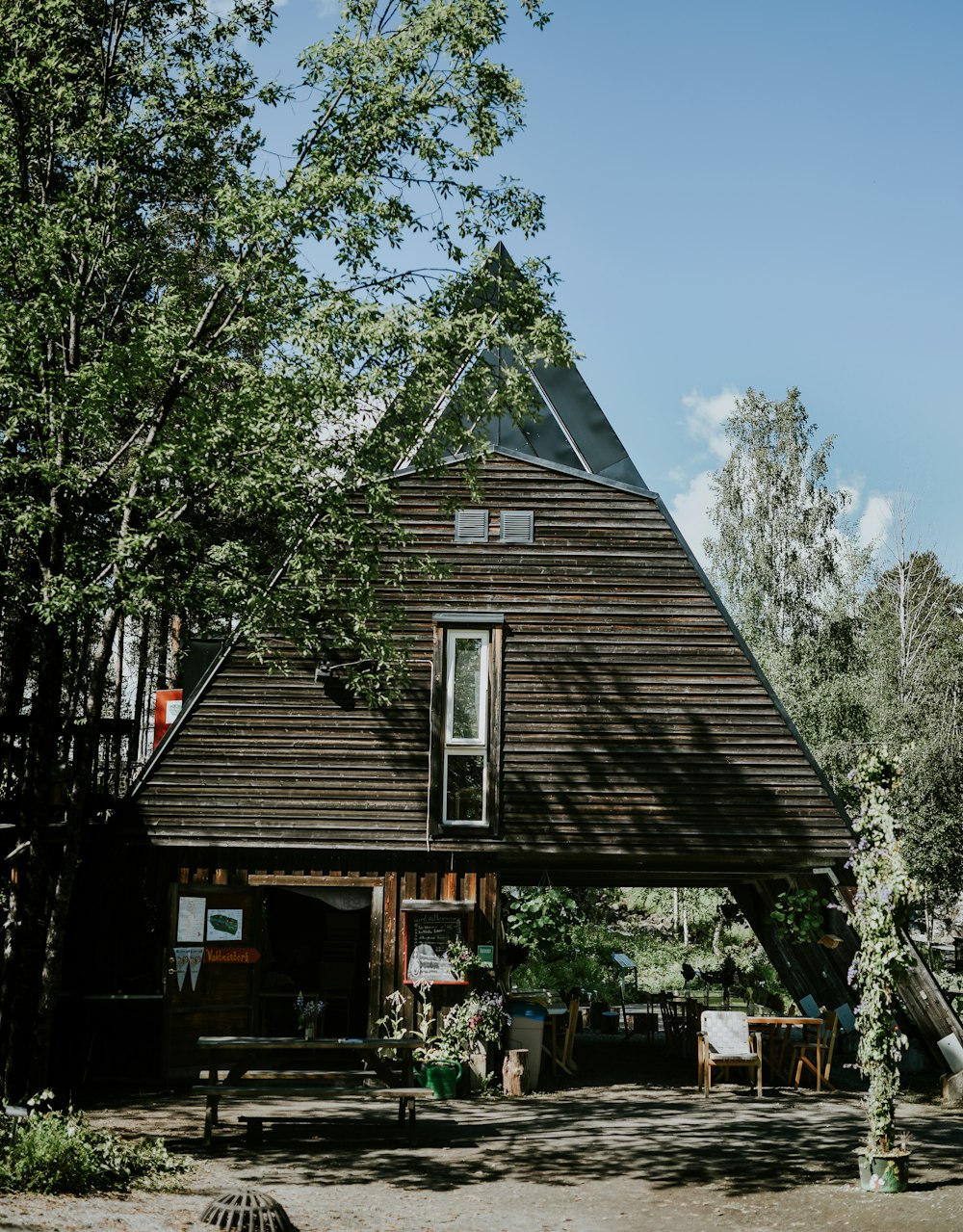 brown wooden house near green trees during daytime