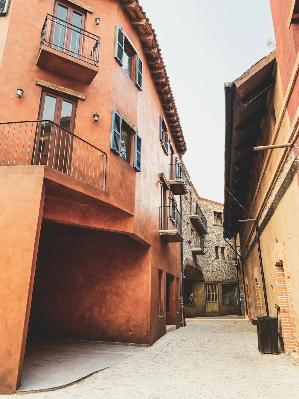 a narrow alleyway between two buildings with balconies