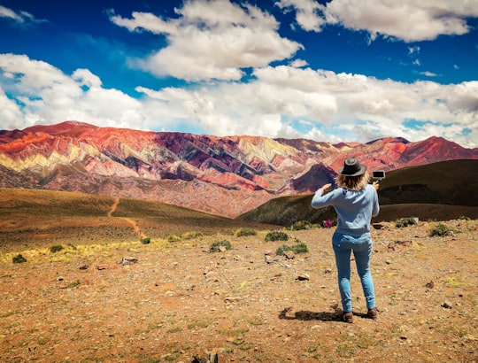 man in white shirt and blue denim jeans standing on brown field during daytime in Jujuy Argentina