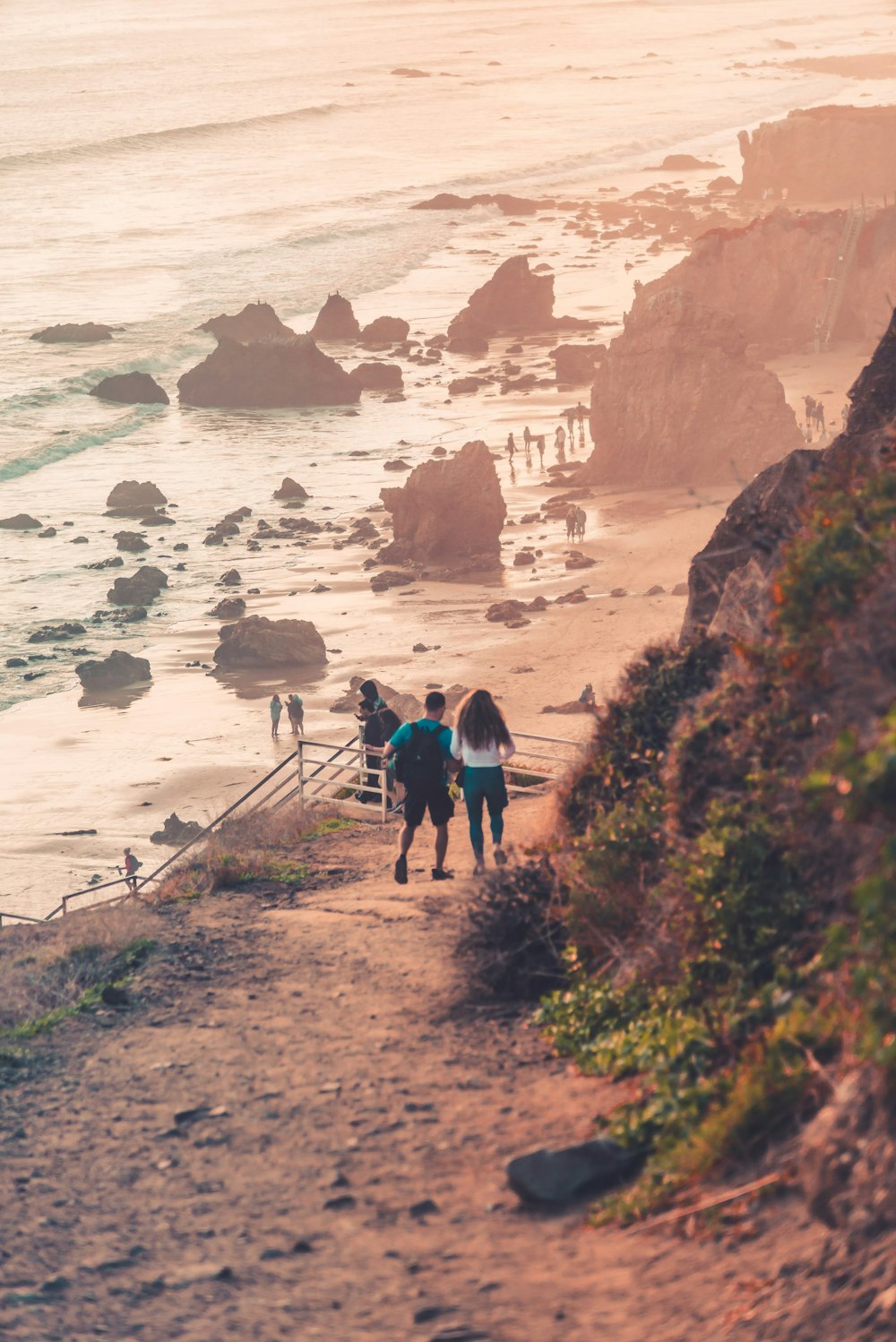 people walking on pathway near body of water during daytime