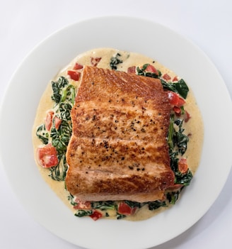 a white plate topped with a piece of fish