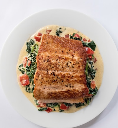 a white plate topped with a piece of fish