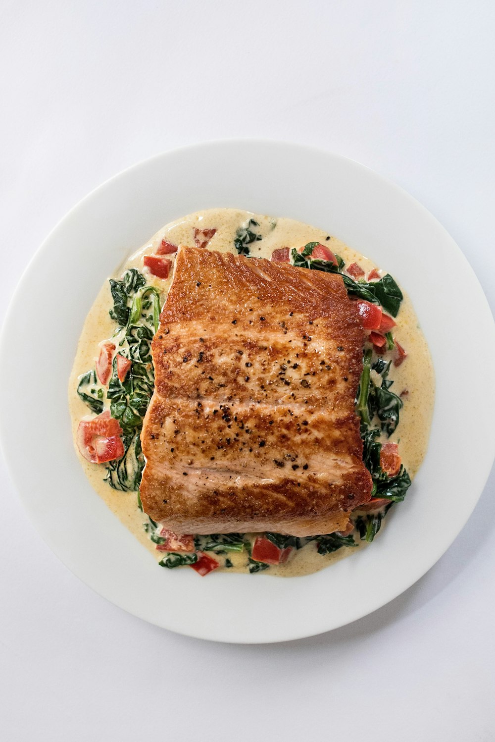 a white plate topped with a piece of fish