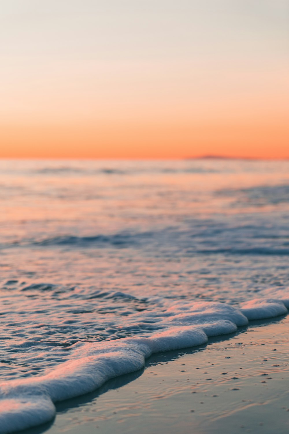 Les vagues de l’océan s’écrasent sur le rivage au coucher du soleil