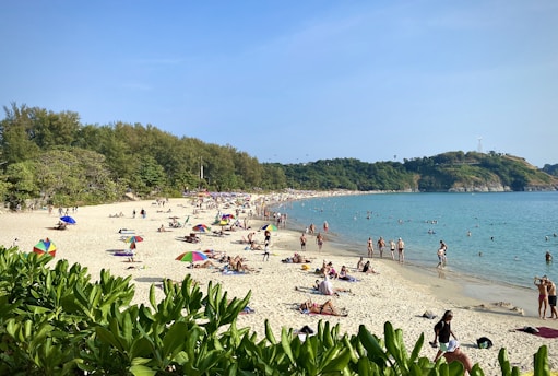 Tourists enjoying a sunny day at a lively North Goa beach.