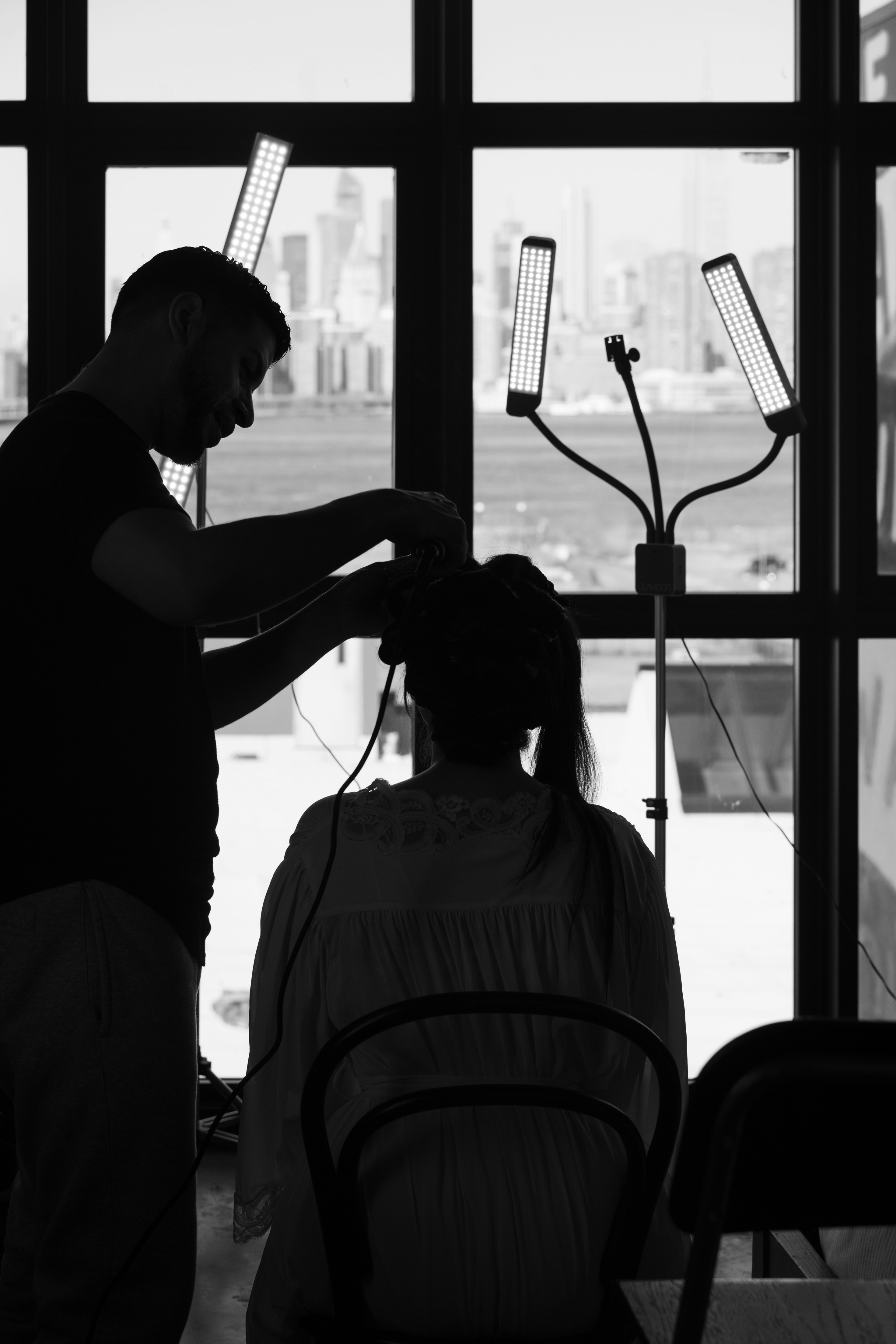 Tony Boza meticulously styling a client's hair with professional precision