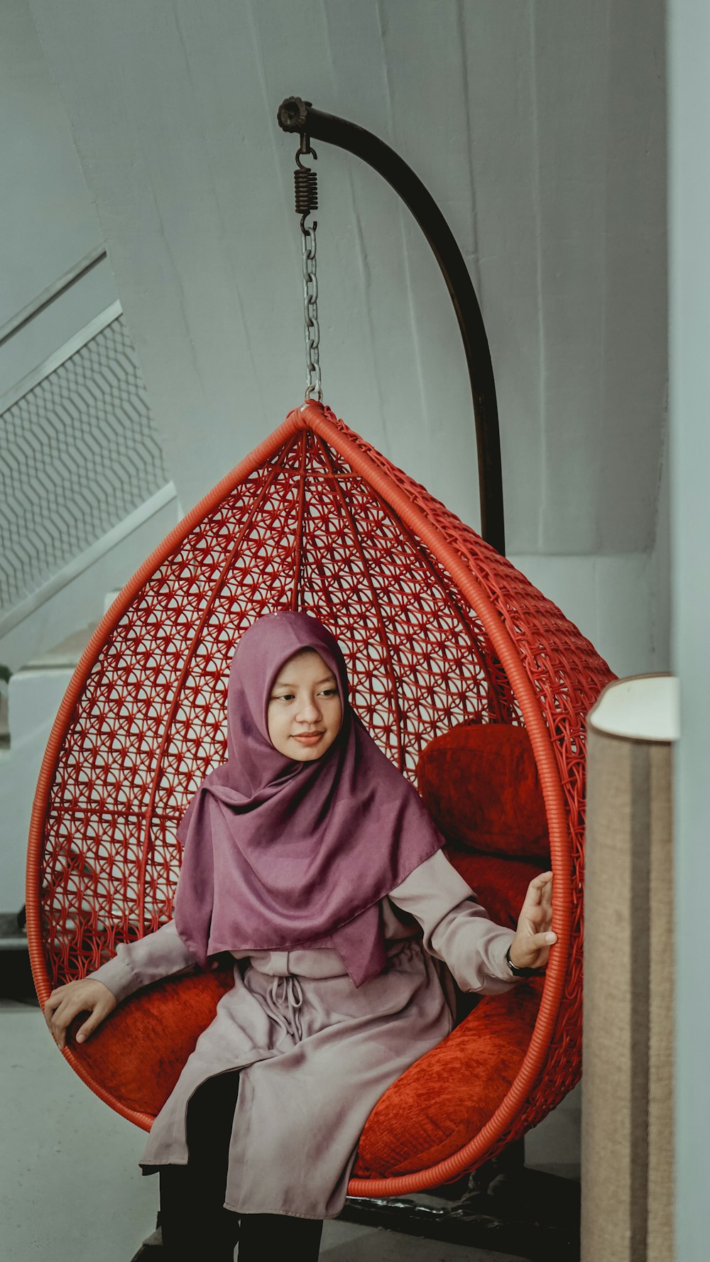 woman in purple hijab sitting on red chair