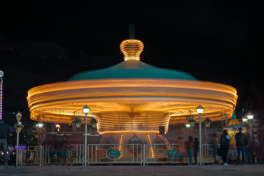 white and brown carousel with lights turned on during night time