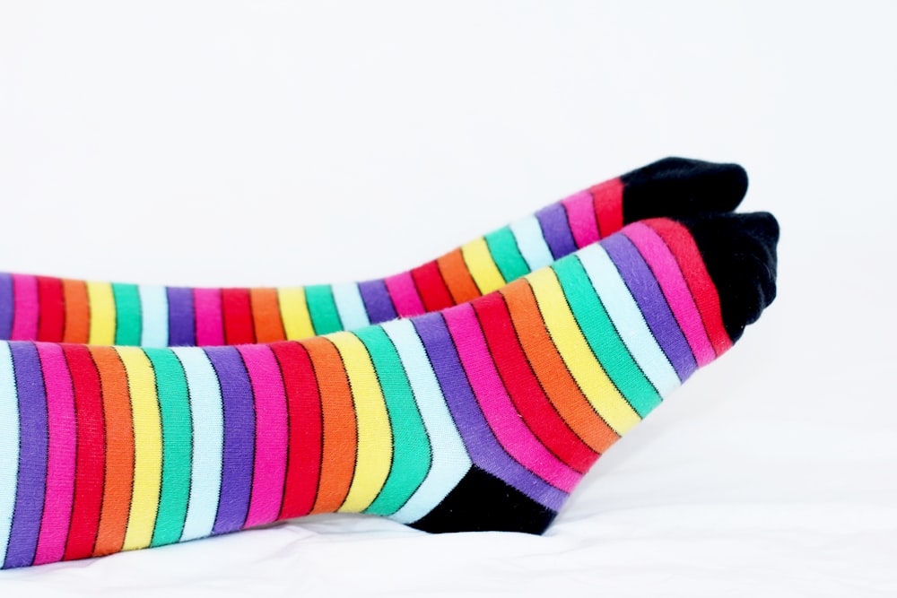 a pair of colorful socks sitting on top of a bed
