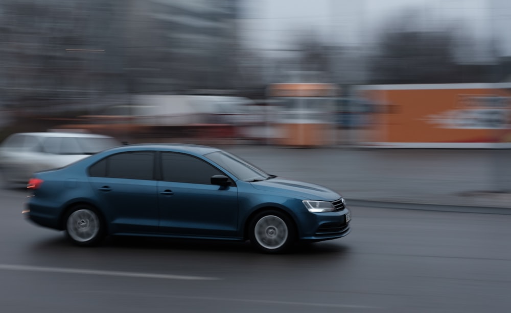 blue sedan on road during daytime