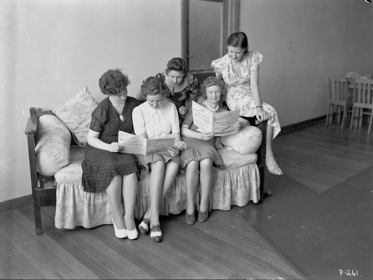Grayscale image of five adults discussing character education ideas while seated on a sofa in a casual setting.