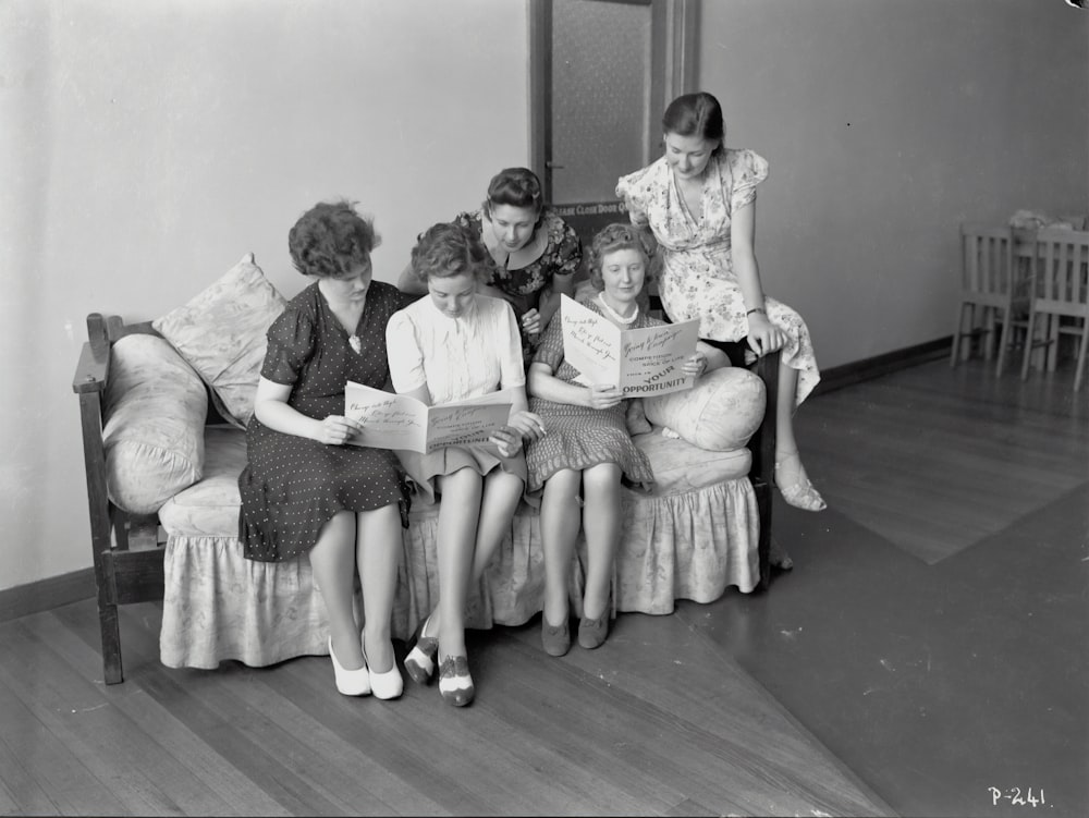 grayscale photo of 3 women and 2 men sitting on sofa