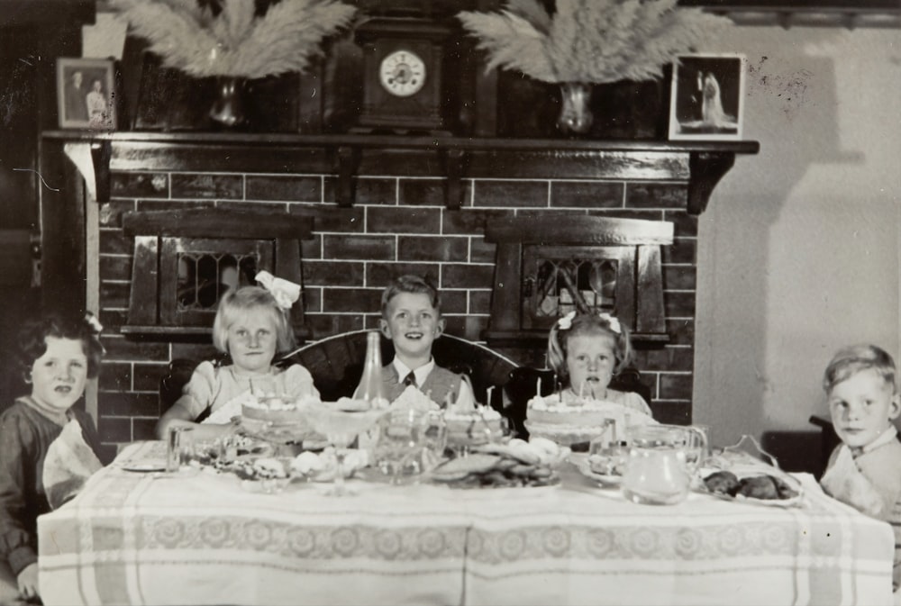 grayscale photo of family on table