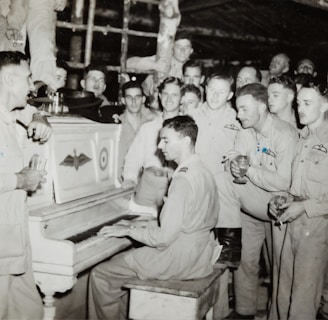 grayscale photo of 4 men standing beside piano