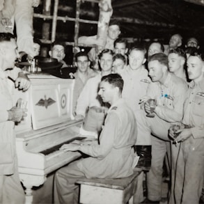 grayscale photo of 4 men standing beside piano