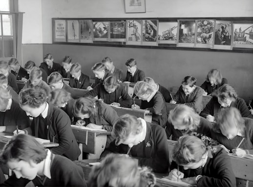 grayscale photo of people sitting on chair
