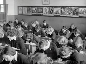 An educator writing on a whiteboard while students eagerly take notes in a modern classroom.