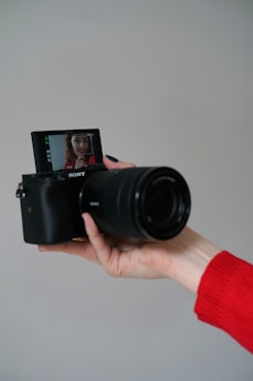 person holding black nikon dslr camera