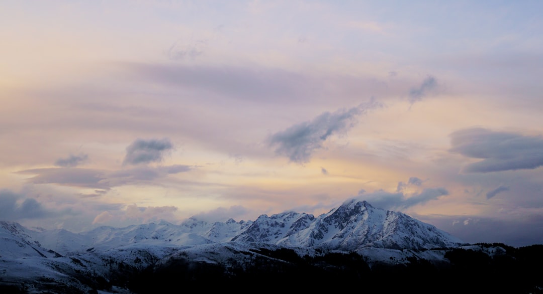 snow covered mountains under cloudy sky during daytime