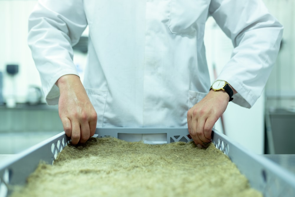 person in white long sleeve shirt holding gray tray