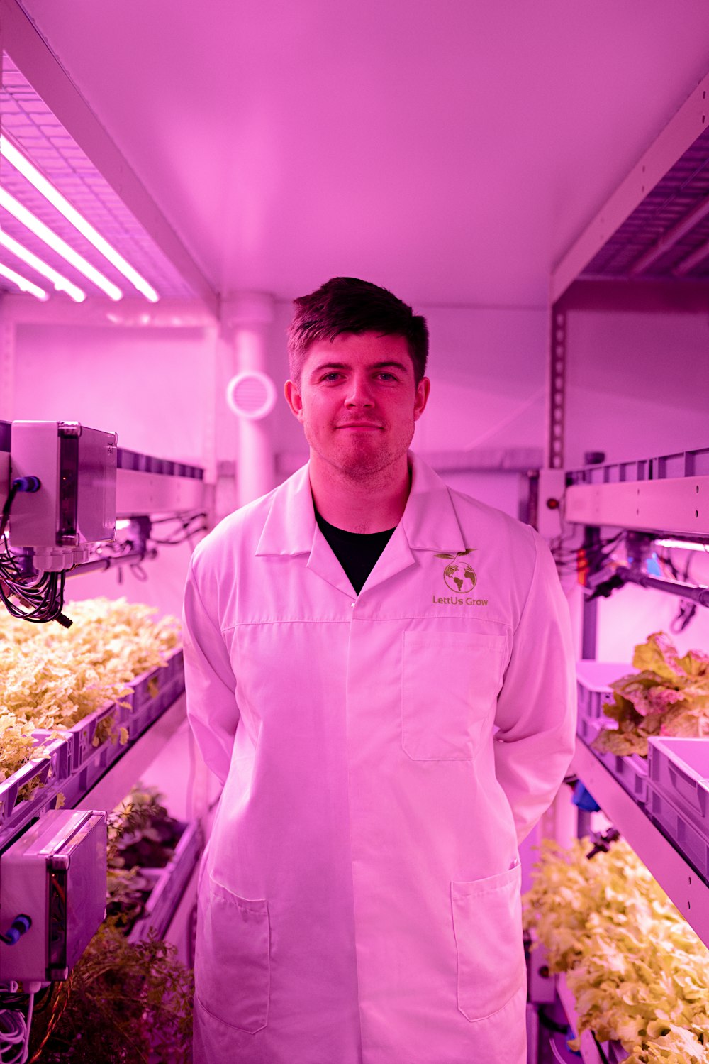 man in white button up shirt standing in front of fruit stand