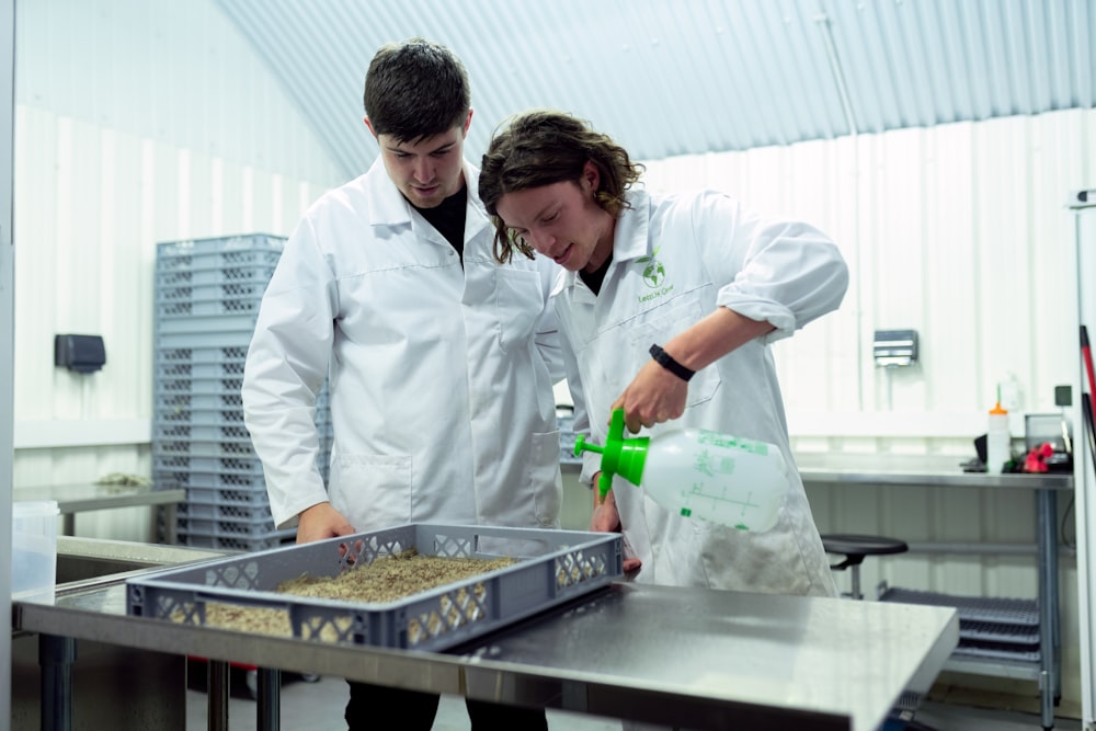 homme en uniforme de chef blanc tenant une bouteille verte