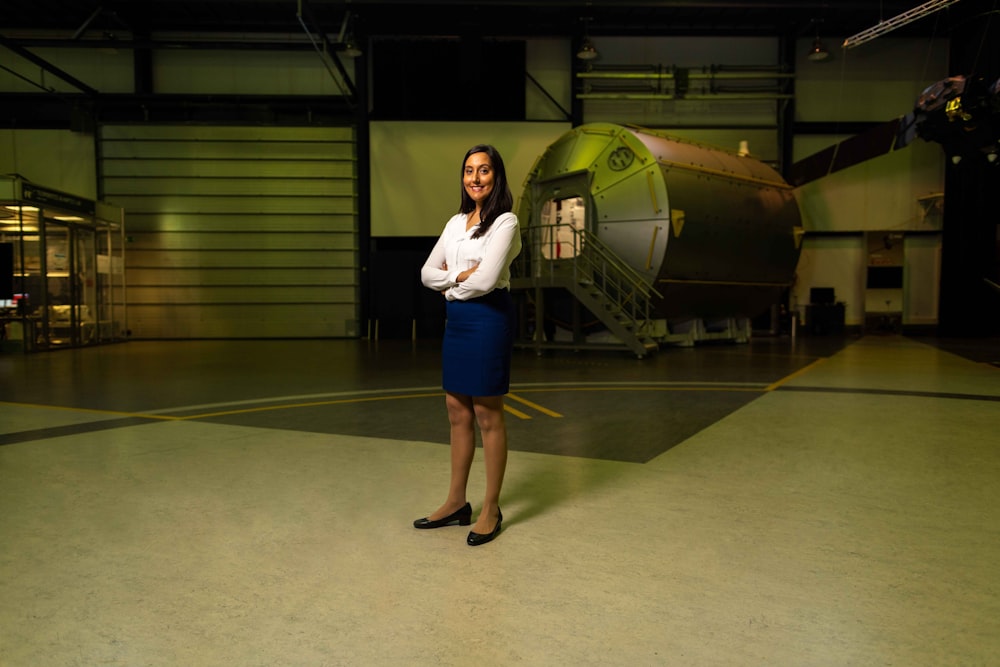 woman in white shirt and blue denim shorts standing on green floor