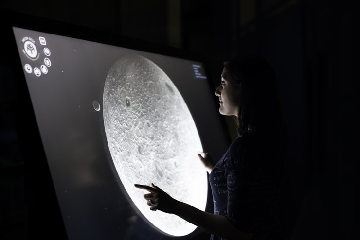 Female space operations engineer uses moon viewing screen