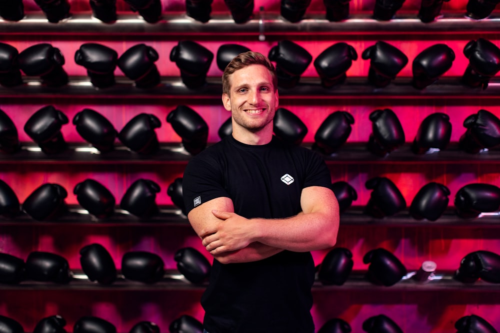 man in black crew neck t-shirt standing near shoes