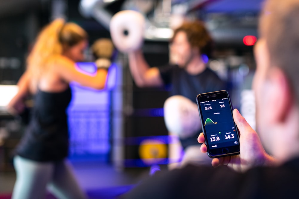 person holding black smartphone taking photo of man in black shirt